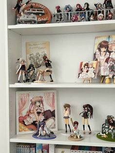 several shelves with anime figurines and books on them in a white bookcase