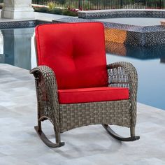 a red chair sitting on top of a patio next to a pool