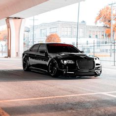 a black car is parked under an overpass