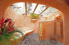 an outdoor bathroom with stone flooring and plants in the shower area, along with a skylight