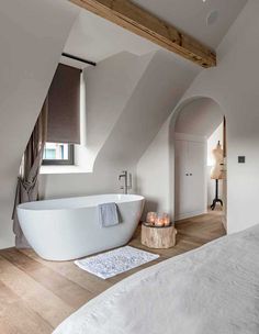 a large white bath tub sitting under a window