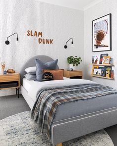 a bedroom with a bed, nightstands and pictures on the wall above it that says slam dunk