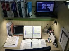 an open book sitting on top of a desk next to a laptop computer