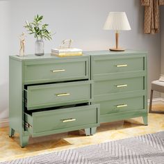 a green dresser with two drawers and a lamp next to it on a rug in a room