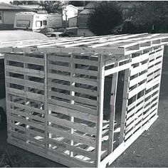 a small white van parked next to a wooden structure