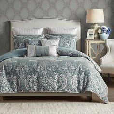 a bed with blue and white comforters in a bedroom