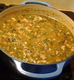 a blue pot filled with soup sitting on top of a stove