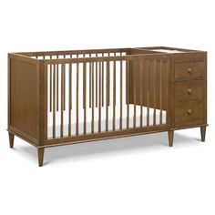 a wooden crib with two drawers and a mattress