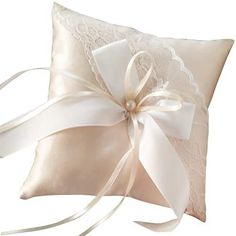 a white pillow with a satin bow on the side and ribbon at the bottom,