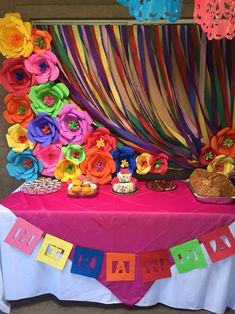 a table topped with lots of colorful paper flowers