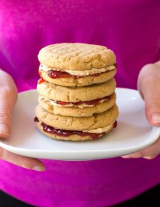 a stack of cookies sitting on top of a white plate next to an orange and pink background