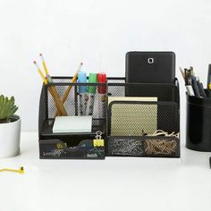 the desk is organized with pens, pencils, and other office supplies on it