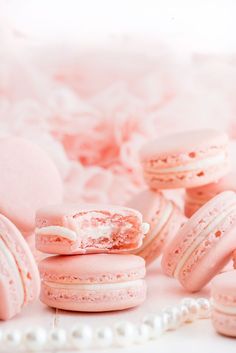 pink macaroons with white frosting and powdered sugar