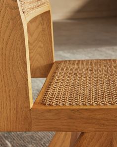 a close up of a wooden chair with wicker seat padding on the back