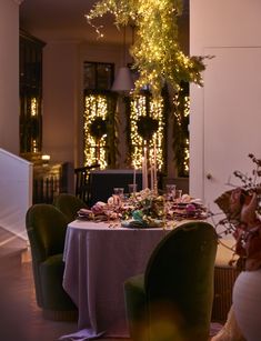 the table is set with candles, plates and silverware for an elegant dinner party