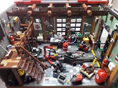 a lego fire station is shown with tools and equipment on the floor in front of it