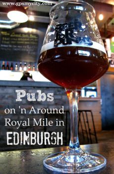 a glass of wine sitting on top of a table in front of a sign that says pub