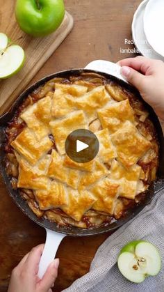 an apple pie in a cast iron skillet on top of a wooden cutting board