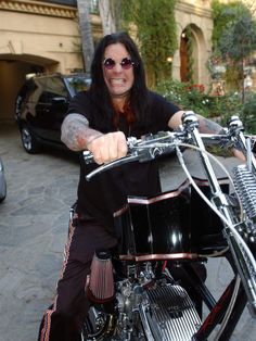 a man sitting on top of a black motorcycle