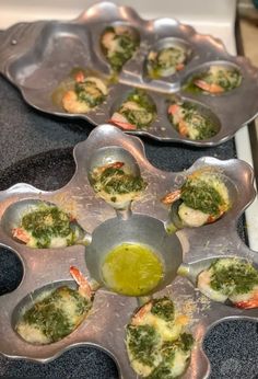 several trays filled with different types of food on top of a stove burner