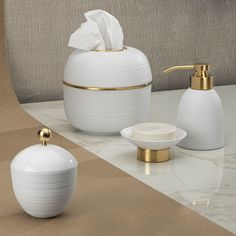 white bathroom accessories with gold accents on the counter