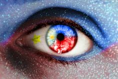 an eye with the colors of the philippines flag painted on it's iris is shown