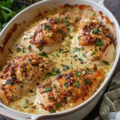 a close up of a chicken dish in a casserole with cheese and herbs