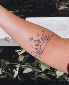 a woman's arm with a tattoo on it that has the sun and stars