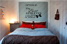 a bed room with a neatly made bed and a wall decal above it that says option 1 the best athletes wear bows