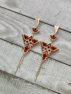 two beaded earrings on top of a wooden table