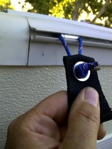 a hand holding a small black piece of cloth with a blue cord attached to it