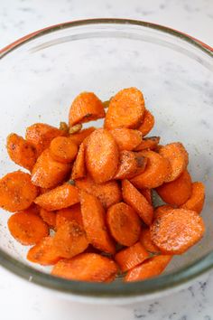 a glass bowl filled with sliced up carrots