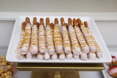 several desserts are arranged on a white platter with gold trimmings and sprinkles