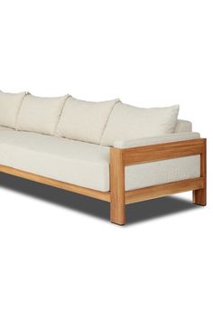 a wooden couch with white pillows on it's back and side cushions, against a white background