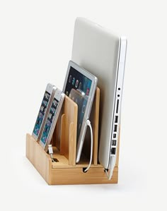 a cell phone, tablet and laptop in a wooden holder