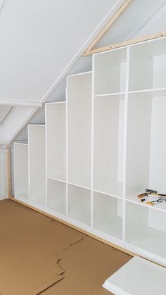 an empty room with white shelving in it