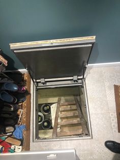 an overhead view of shoes and other items in a storage area on the floor next to a laptop computer