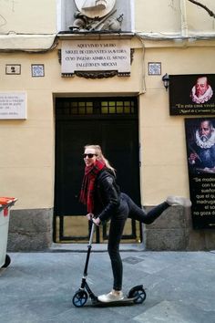 a woman riding an electric scooter in front of a building