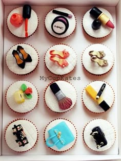 cupcakes decorated with different types of items in a white box on top of a table