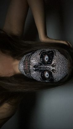 a woman's face is covered in silver beads and eyes are seen from above