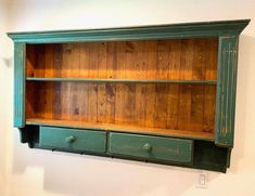 an old green bookcase with two drawers