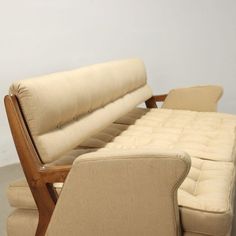 a couch and chair sitting next to each other on the floor in a room with white walls