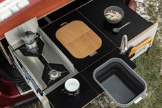 a stove top oven sitting on top of a wooden table next to a bowl of food