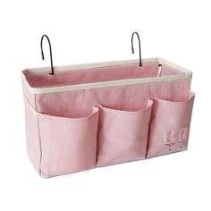 three pockets hanging on the side of a pink storage bag with black handles and hooks