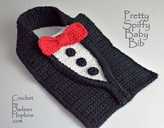 there is a crocheted black and white sweater with a red bow on it