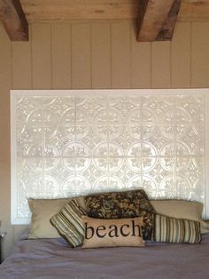 a bed with some pillows on top of it and a headboard made out of wood beams