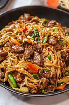 a close up of a plate of food with noodles and meat in it on a table