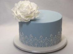 a blue and white cake with a flower on top