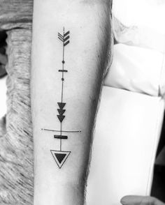 a black and white photo of an arrow tattoo on the left inner arm with arrows in it