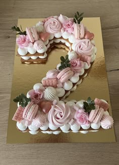 the number two is made out of pink and white frosting with flowers on it